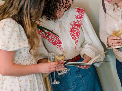 women at art launch with champagne